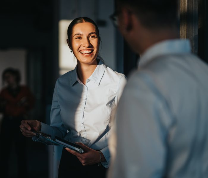 a business woman smiling at a man in a panel of sunlight